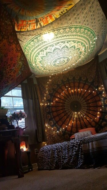 a room with a bed covered in blankets and lights