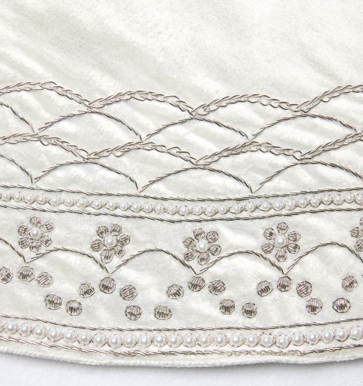 a close up of a white dress with beading on it