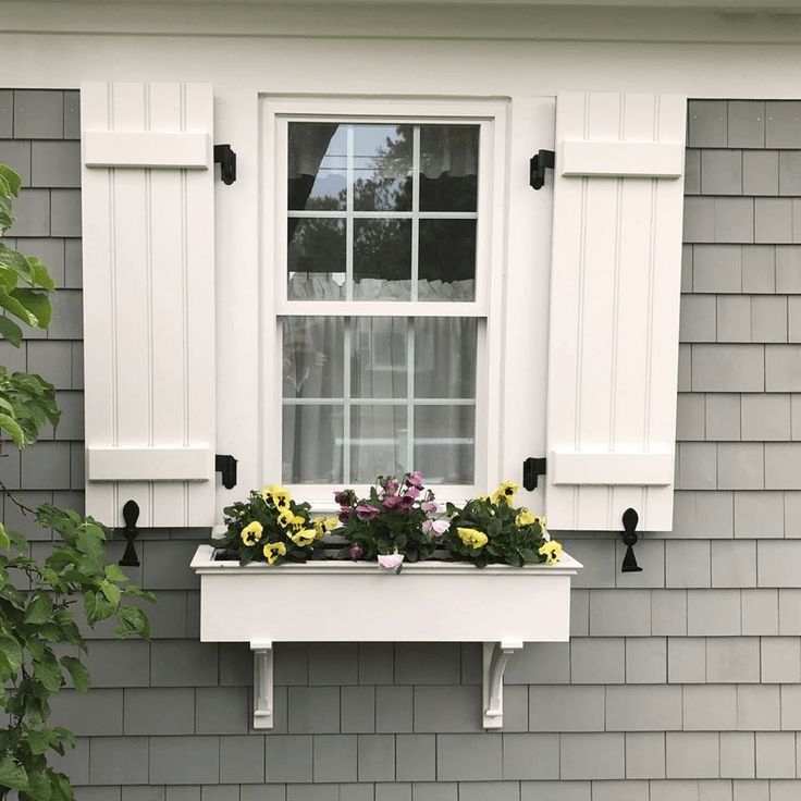 a window box with flowers in it on the side of a house