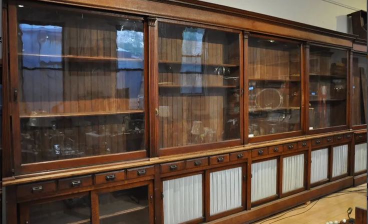 an old wooden bookcase with many glass doors