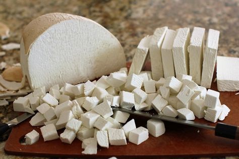 there are many pieces of tofu on the cutting board next to it is a knife