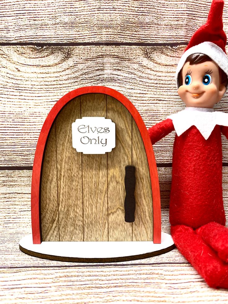 an elf is standing next to a wooden door