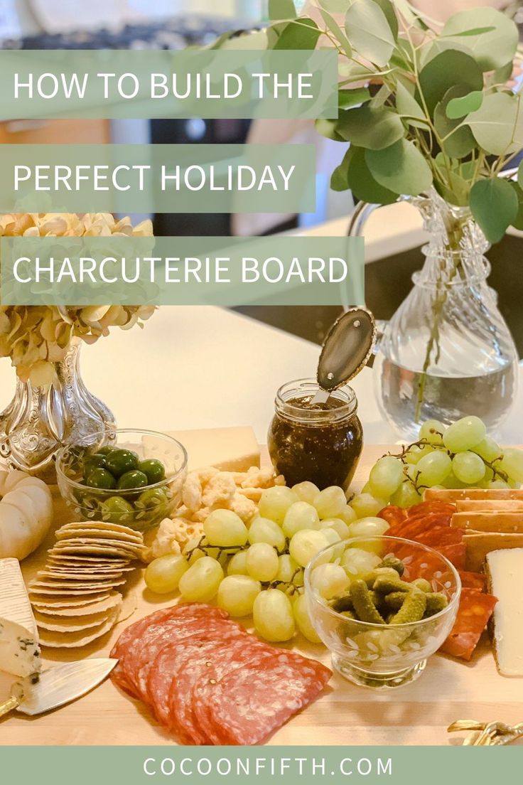 a wooden table topped with lots of different types of cheese and meats next to a vase filled with flowers