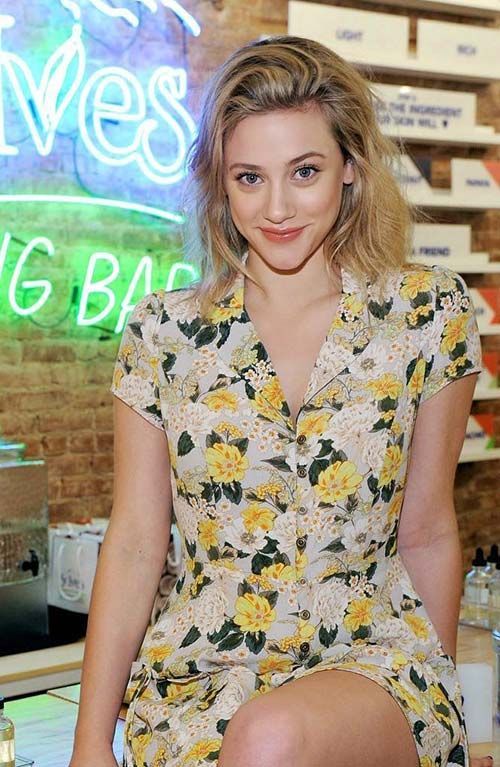 a young woman sitting on top of a stool in front of a sign that says big bag