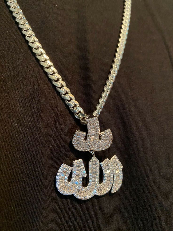 "Iced Out Baguette Allah pendant! CHAIN IS NOT INCLUDED Fits chains up to 10mm thick Arabic calligraphy - very powerful symbol SUPER ICY!....AAAAA rated CZ stones, not cheap cloudy crap. Solid 925 sterling silver...never turns green This is a lifetime piece 1.5\" by 1.75\" Weighs 17 grams Color doesn't change as its real 925 sterling silver 14k gold option has real yellow gold bonded to natural silver" Luxury White Curb Chain Jewelry, Luxury Personalized Cuban Link Jewelry, Silver Cubic Zirconia Nameplate Jewelry, Silver Iced Out Nameplate Jewelry, Luxury Silver Jewelry With Curb Chain, Silver Nameplate Chain Jewelry, Allah Pendant, White Gold Pendant Necklace, Gold Bond