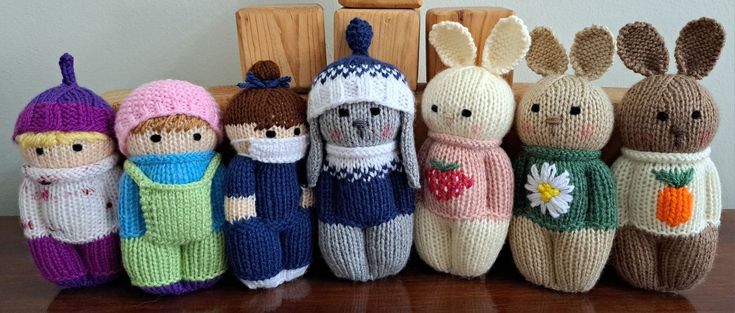 a group of knitted dolls sitting next to each other