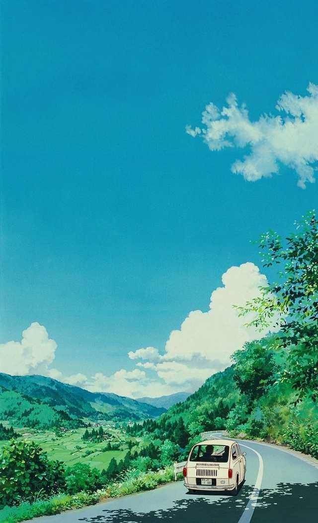 a car driving down the road with mountains in the backgrouund and clouds in the sky