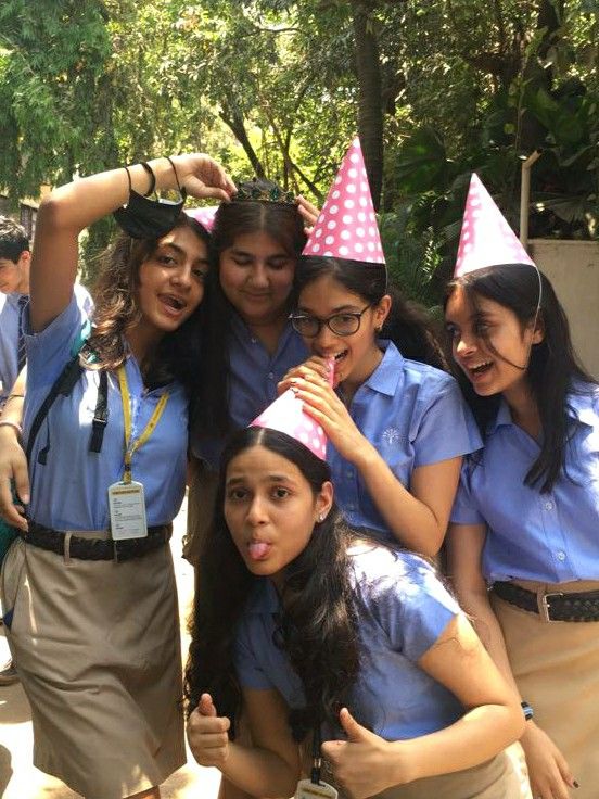 a group of young women standing next to each other wearing party hats on their heads