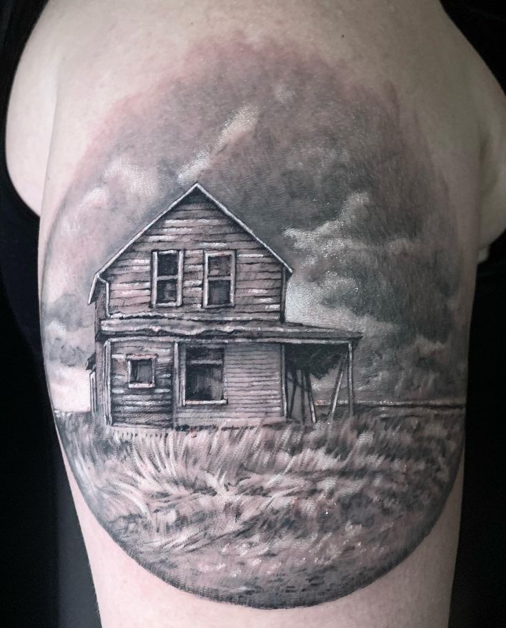 a black and white photo of a house on the back of a woman's shoulder