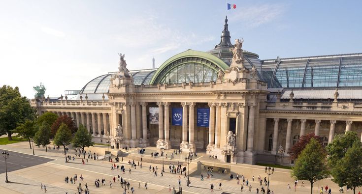 an aerial view of people walking around in front of a building with glass roof and dome