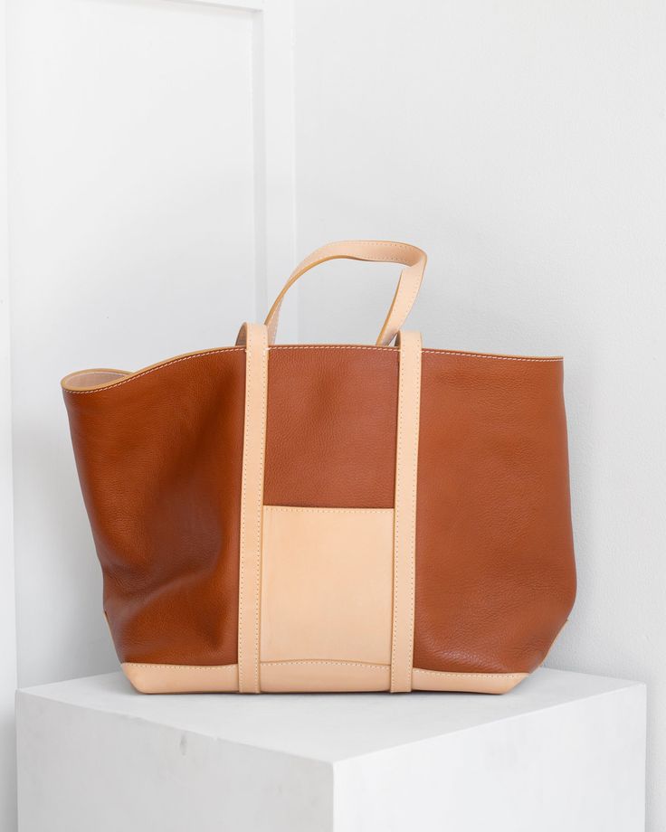 An everyday shoulder and hand-carry tote and a love poem to an icon. This iteration of Chelito is constructed entirely of raw vachetta leather, yielding a tonal tote that is sophisticated and strikingly lightweight. We love vachetta not only for its structural integrity and smooth finish, but for it's transformative potential. Each of these objects will become entirely unique over time; developing particular patina, aging with individual grace and character. Leather Bucket Bag With Handle Drop For Daily Use, Leather Bucket Bag With Handle Drop For Everyday Use, Beige Leather Tote Weekender Bag, Everyday Brown Bag With Handle Drop, Beige Leather Weekender Bag For Shopping, Everyday Leather Shoulder Bag With Handle Drop, Beige Satchel With Leather Backing, Vegetable-tanned Leather Tote Satchel, Vegetable-tanned Leather Satchel Tote