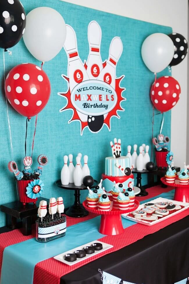 a bowling themed birthday party with cake, balloons and decorations on a blue wall background