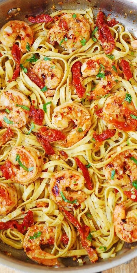 pasta with shrimp and tomato sauce in a pan on a wooden table, ready to be eaten