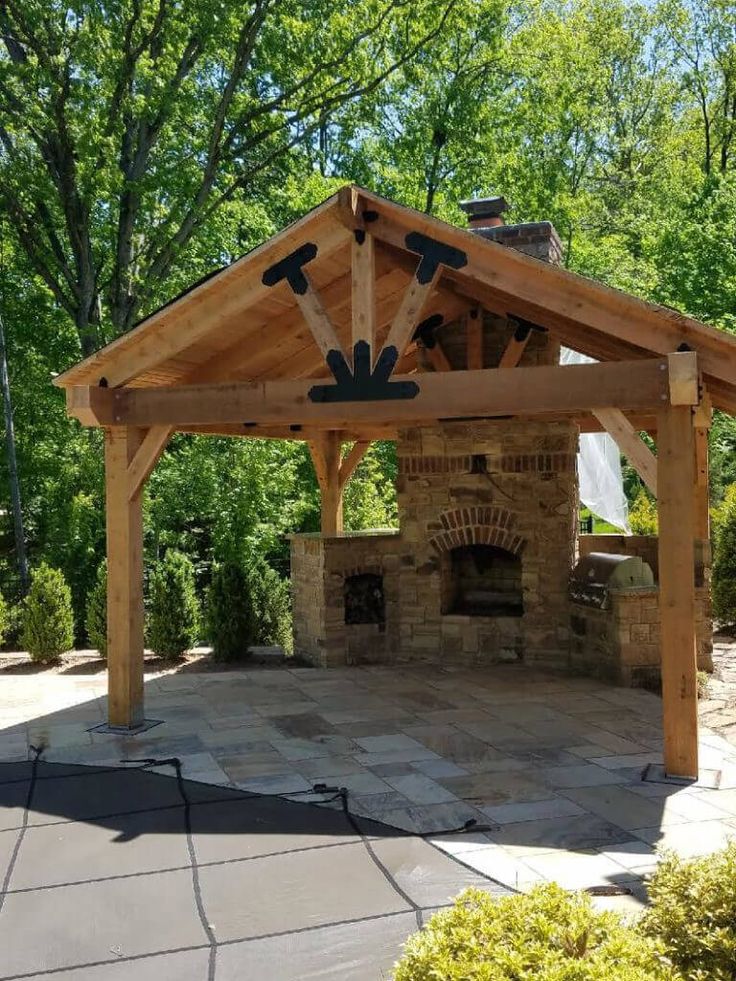 a gazebo with an outdoor fireplace in the middle