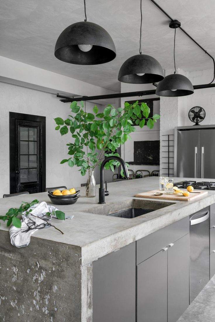 a large kitchen with an island counter top and two lights hanging from the ceiling above it