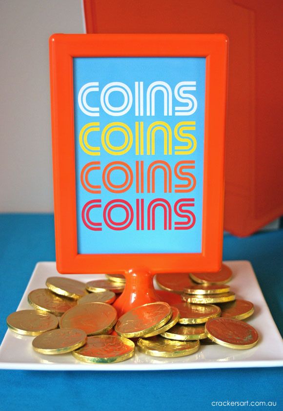 coins are sitting on top of a white plate with a blue and orange sign in the background