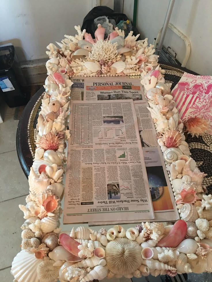 a newspaper with seashells on it sitting on a table next to a chair