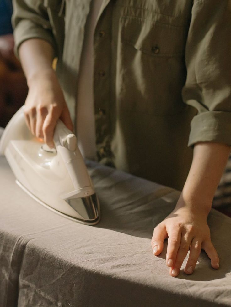 a person ironing fabric with a white iron