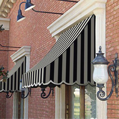 a black and white awning on the side of a building next to a street light