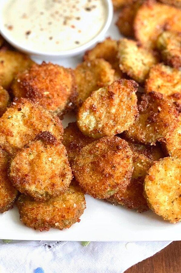 some fried food on a white plate with dipping sauce