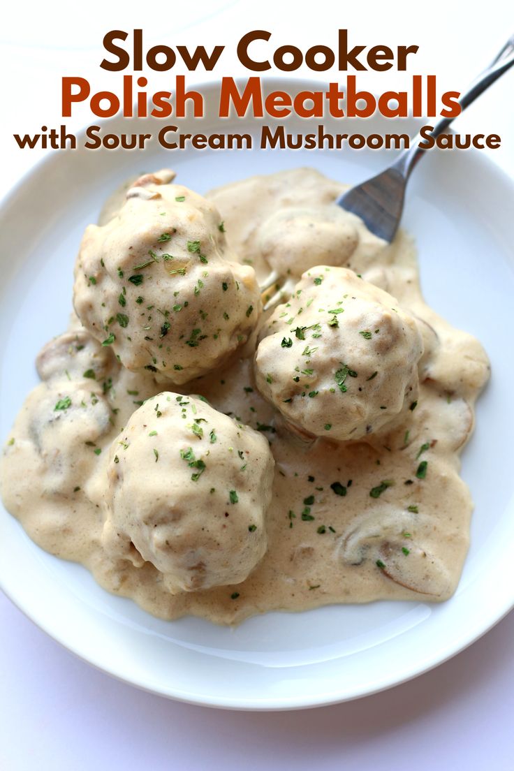 a white plate topped with meatballs covered in gravy next to a fork