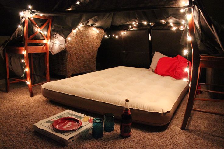 there is a bed with lights on it and some bottles in front of the bed