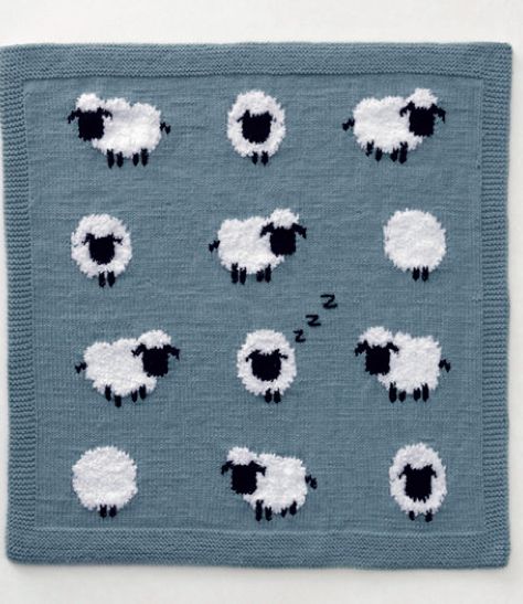 a knitted blanket with black and white sheep in the middle on a blue background