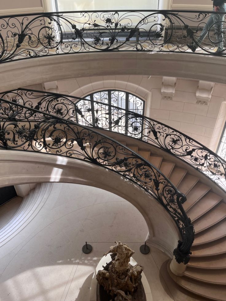 a spiral staircase with wrought iron railings