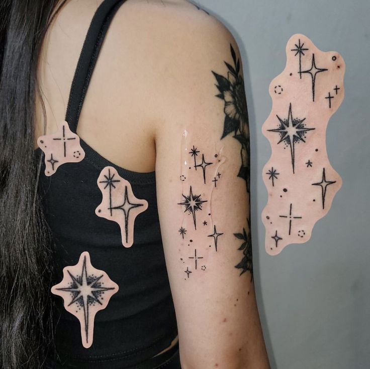 a woman's arm with stars and crosses on it