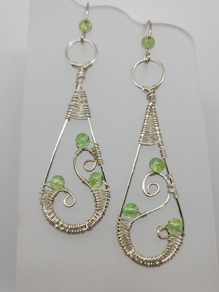 Silver artistic wire wrapped with green glass beads Green Teardrop Beaded Earrings With Wire Wrap, Green Teardrop Beaded Earrings With Wire Wrapped Detail, Green Teardrop Wire Wrapped Beaded Earrings, Green Wire Wrapped Teardrop Beaded Earrings, Nickel-free Green Metal Beaded Earrings, Green Wire Wrapped Metal Earrings, Green Teardrop Nickel-free Chandelier Earrings, Green Teardrop Chandelier Earrings Nickel Free, Handmade Green Metal Chandelier Earrings