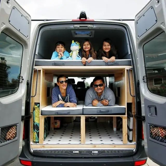 three people sitting in the back of a van