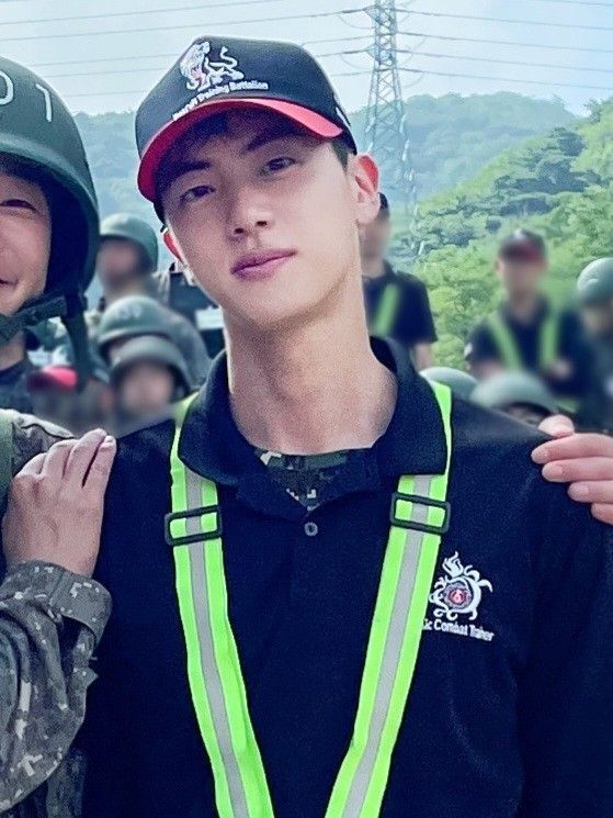 two young men standing next to each other in front of a group of people wearing helmets