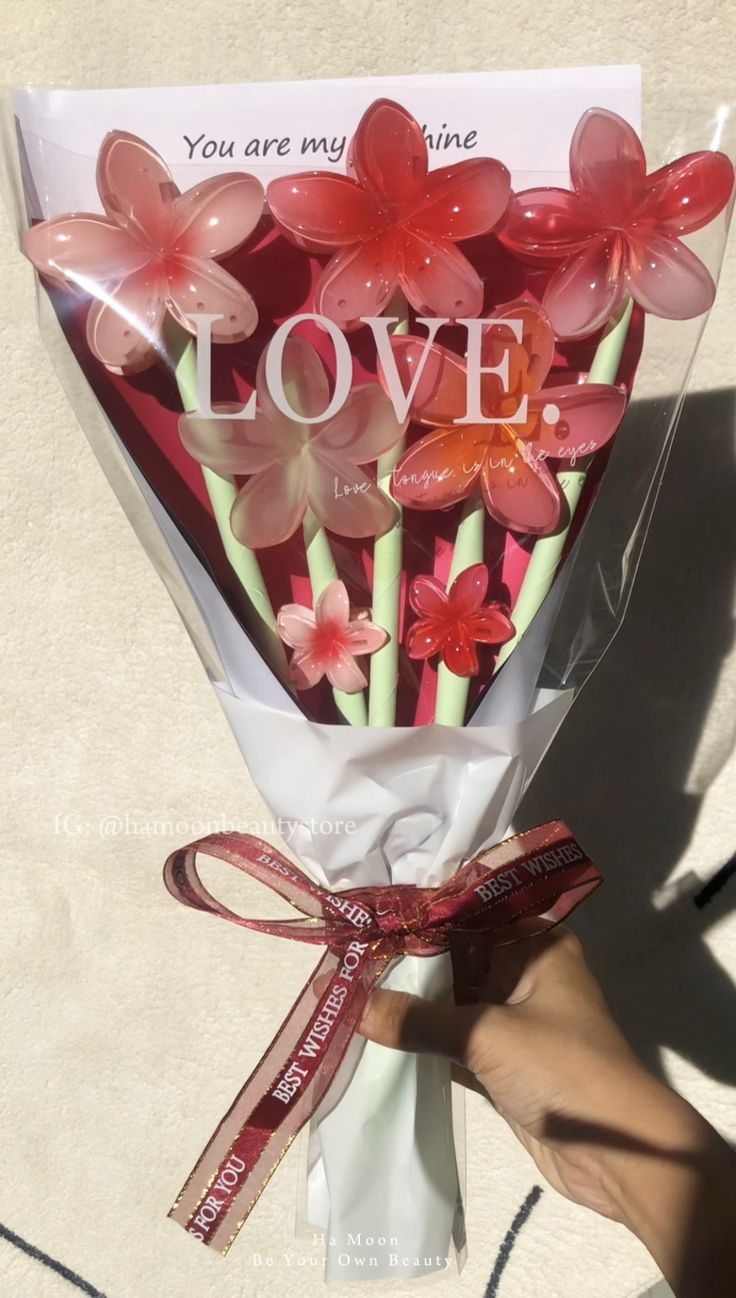 someone is holding a bouquet of flowers with the words love on it and you are my valentine