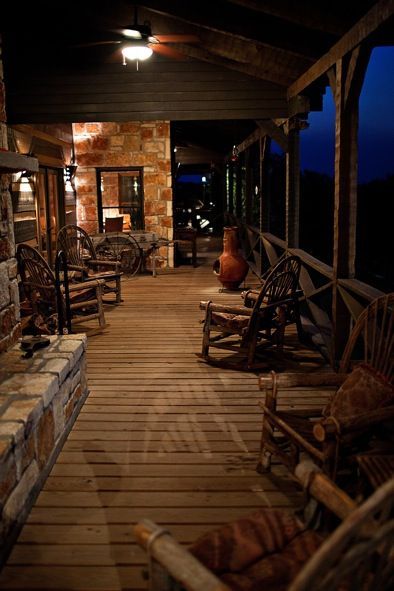 a porch with rocking chairs on it at night