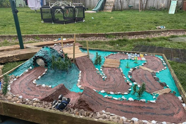 a cake made to look like a pond with rocks and trees on it in the middle of a yard