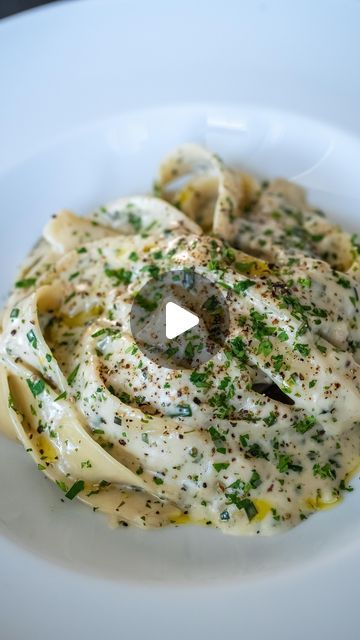 a white plate topped with pasta covered in sauce