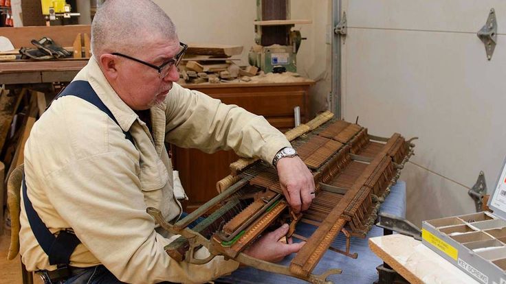 an older man is working on a piece of wood