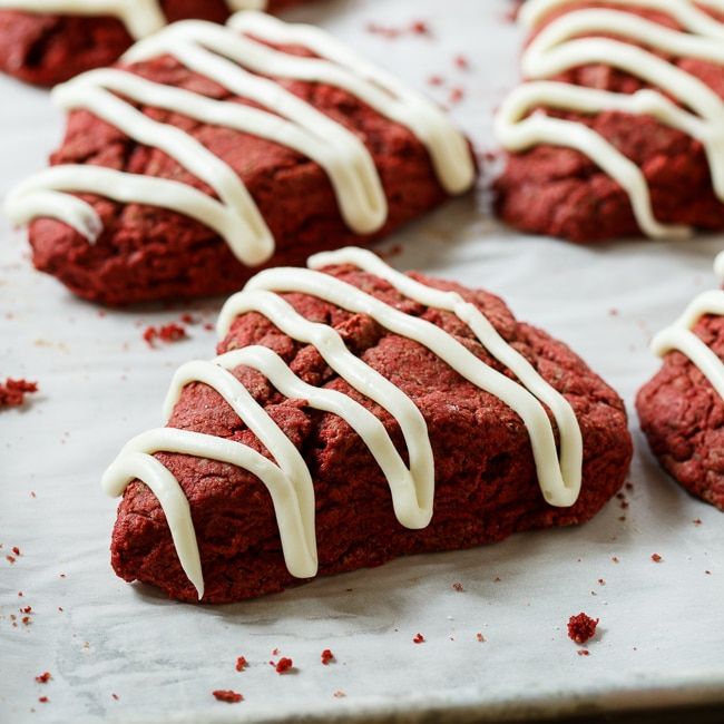 red velvet cookies with white icing on a baking sheet