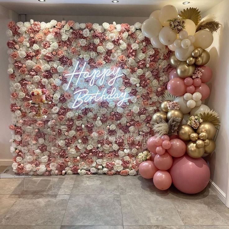 a birthday backdrop with balloons and streamers on the wall, along with a sign that says happy birthday