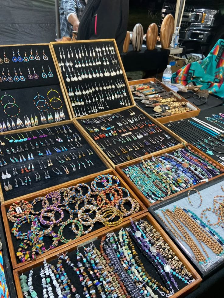 an assortment of jewelry is on display for sale at a street vendor's stall