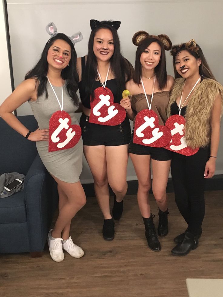 four girls dressed in costumes holding up heart shaped signs with the letters i love you on them