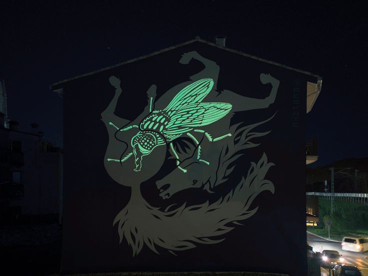 a lit up bee on the side of a building