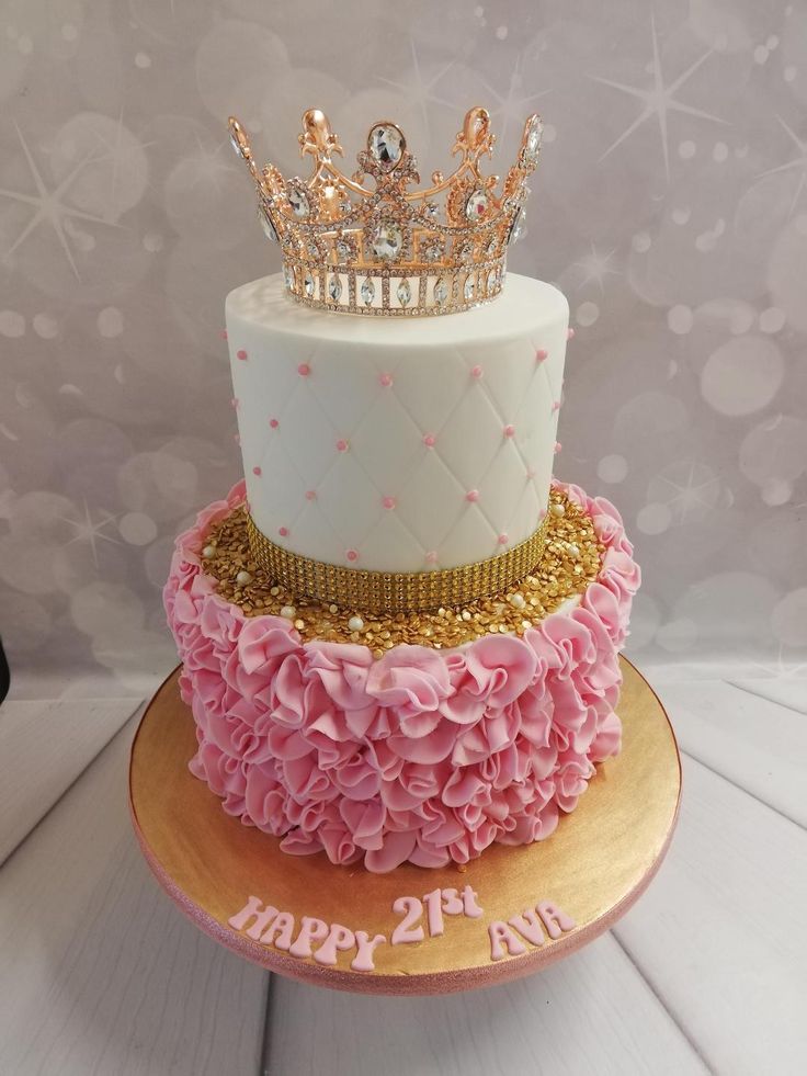 a three tiered cake with pink ruffles and a crown on top