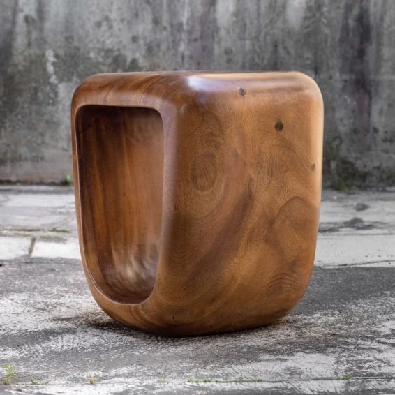 a wooden object sitting on top of a cement floor