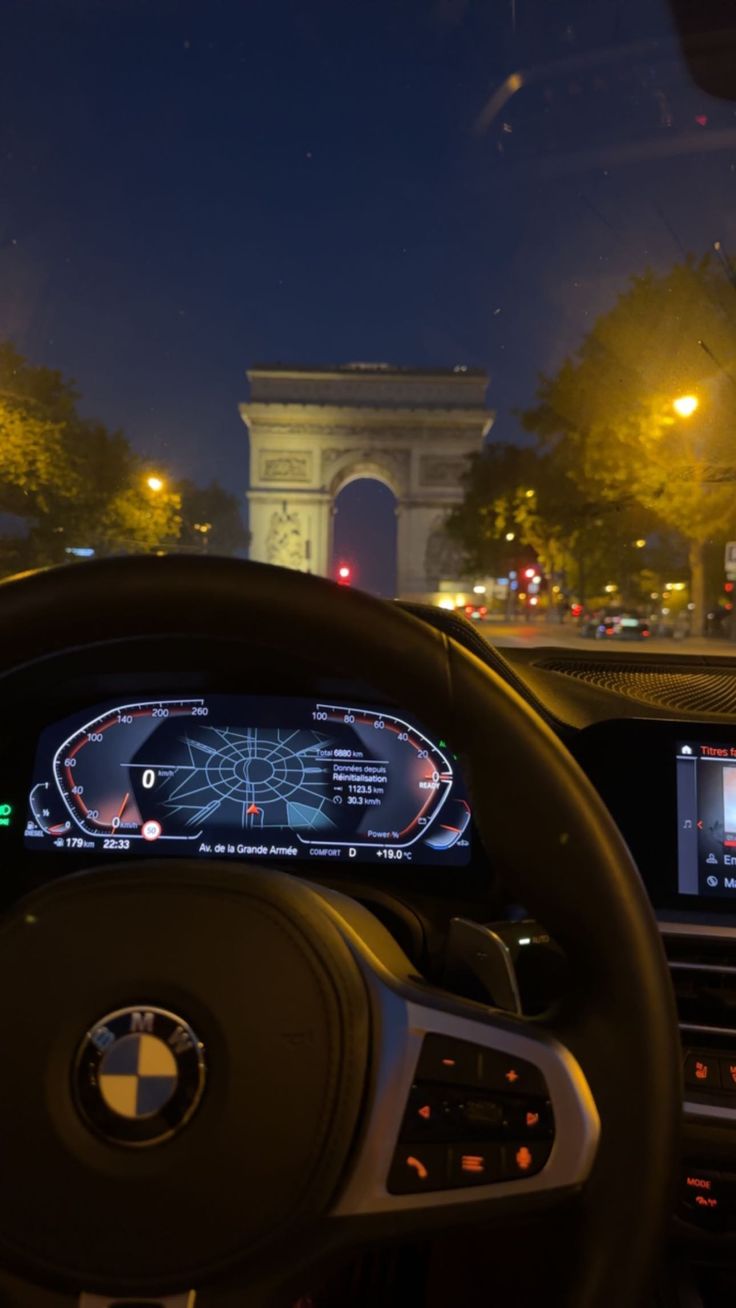 the dashboard of a car in front of an arc de trioe triumph monument at night