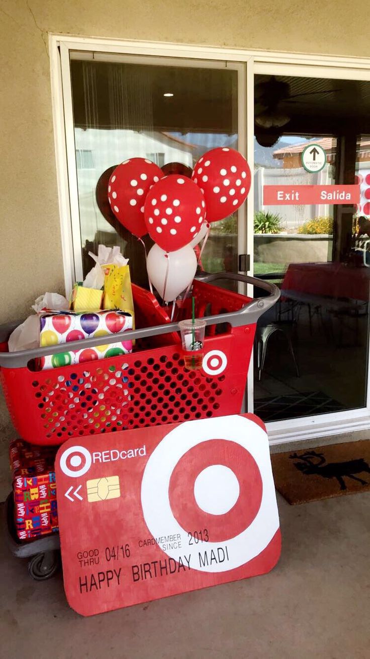 a shopping cart filled with balloons and other items in front of a target store window