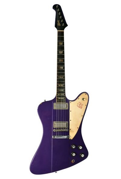 an electric guitar with a purple body and gold head on the neck, sitting against a white background