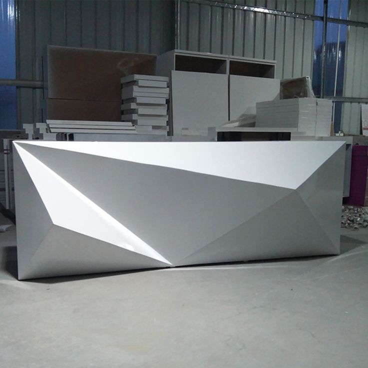 a large white counter sitting inside of a warehouse next to stacks of boxes and other items