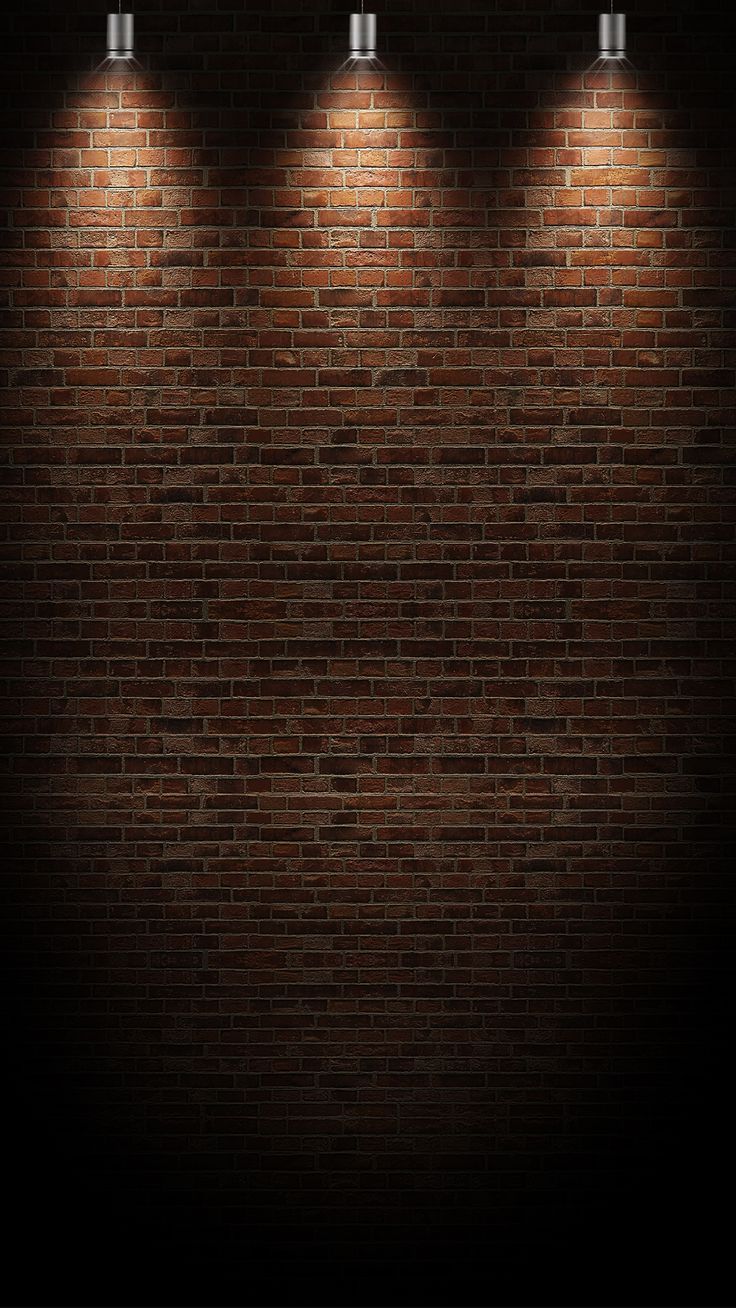 three spotlights on a brick wall in the dark