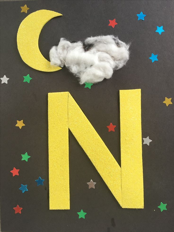 the letter n is made out of foam and cotton balls with stars around it on a black background